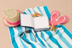 telo mare con libro, cappello a occhiali da sole
