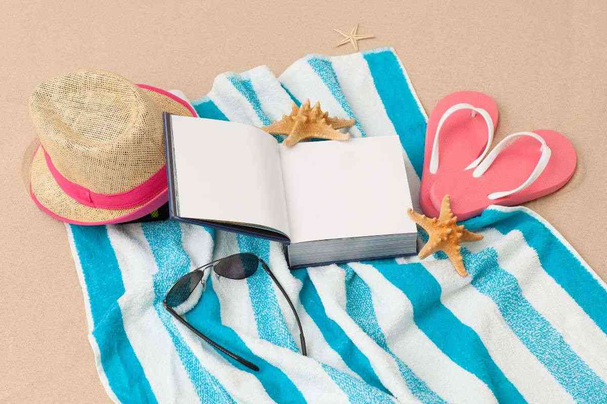 telo mare con libro, cappello a occhiali da sole