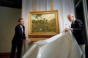 "Tramonto a Montmajour” di Van Gogh e due persone che lo mostrano al pubblico