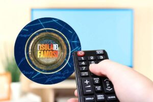 Telecomando puntato alla TV e logo de L'isola dei famosi