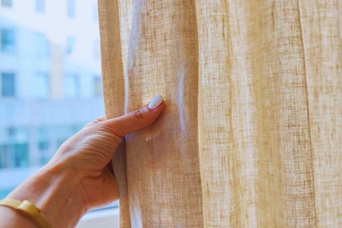 una mano che tocca una tenda