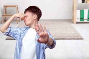 tappeto e ragazzo che si tappa il naso