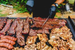 un uomo alla brace con la carne