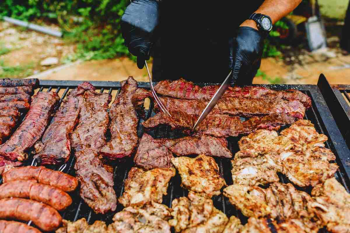 un uomo alla brace con la carne