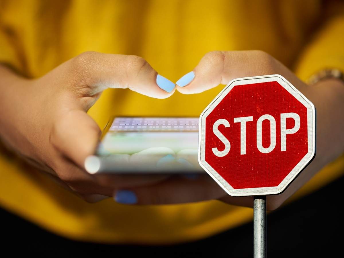 donna che usa smartphone e segnale stop